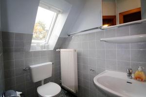 ein Bad mit einem WC, einem Waschbecken und einem Fenster in der Unterkunft Ferienwohnung Düneneck 14 OG/links in Sankt Peter-Ording