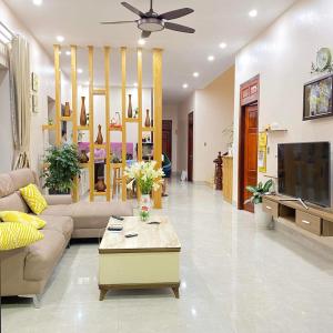 a living room with a couch and a tv at GiaBinh Homestay in Cao Bằng