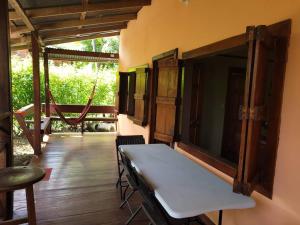 Habitación con mesa, sillas y porche. en CASA VERO CAHUITA, A 100 M. DEL PARQUE NACIONAL en Cahuita