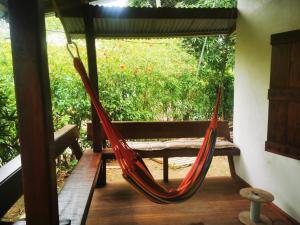卡維塔的住宿－CASA VERO CAHUITA, A 100 M. DEL PARQUE NACIONAL，带长凳的客房内的红色吊床