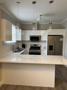 uma cozinha com um balcão branco e um lavatório em SHAK Condos- Luxury, Functionality and Comfort em Saint Helena