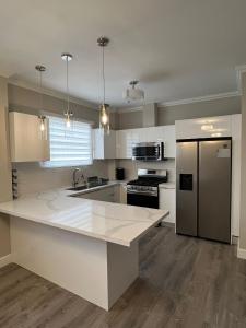 a kitchen with a white counter top and a refrigerator at SHAK Condos- Luxury, Functionality and Comfort in Saint Helena