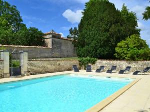basen z krzesłami i ceglaną ścianą w obiekcie Gîte spacieux avec jardin, piscine, cheminée, et équipements bébé au cœur des vignes du Cognac - FR-1-653-59 w mieście Lignières-Sonneville