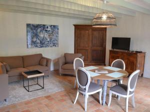 salon ze stołem, krzesłami i kanapą w obiekcie Gîte spacieux avec jardin, piscine, cheminée, et équipements bébé au cœur des vignes du Cognac - FR-1-653-59 w mieście Lignières-Sonneville