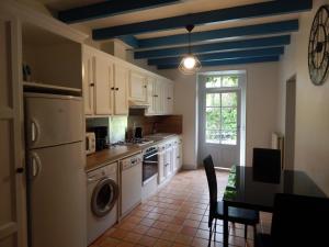 kuchnia z białymi szafkami i niebieskim sufitem w obiekcie Gîte spacieux avec jardin, piscine, cheminée, et équipements bébé au cœur des vignes du Cognac - FR-1-653-59 w mieście Lignières-Sonneville