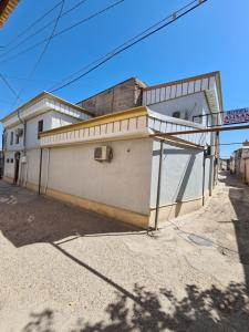 a white building on the side of a street at Bukhara Hotel Alikhan in Bukhara