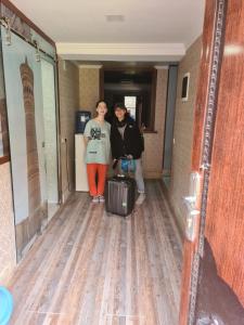 two women standing in a hallway with their luggage at Bukhara Hotel Alikhan in Bukhara