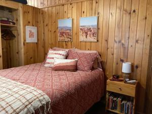 1 dormitorio con 1 cama y paredes de madera en Bryce’s Zion House by Bryce Canyon National Park!, en Panguitch