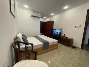 - une chambre avec un lit et une télévision dans l'établissement Senho Hotel, à Hô-Chi-Minh-Ville