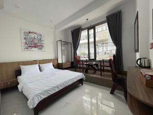 - une chambre avec un lit, une table et une fenêtre dans l'établissement Senho Hotel, à Hô-Chi-Minh-Ville