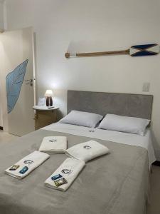 a bed with three pillows on top of it at Casa em condomínio fechado Paraty - KG Home in Paraty