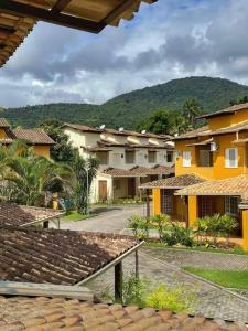 a group of buildings with mountains in the background at Casa em condomínio fechado Paraty - KG Home in Paraty
