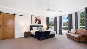a bedroom with a bed and a couch and windows at Cowley House in Dapto