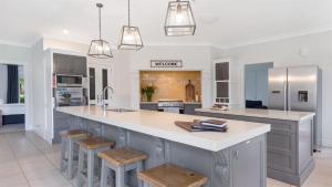 a kitchen with a large island with stools at Cowley House in Dapto