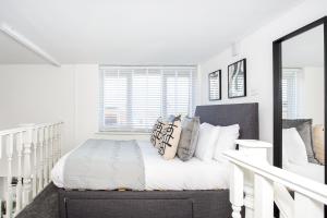 a white bedroom with a bed and a window at Elmsleigh Lofts by Sorted Stay in Southend-on-Sea
