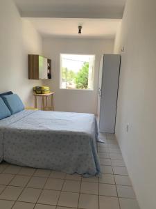 um quarto com uma cama e um frigorífico em casa de 4 quartos perto do Forte Orange Itamaracá em Itamaracá