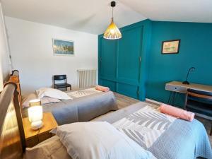 due letti in una stanza con pareti blu di Maison de charme 19ème rénovée proche Angoulême, idéale famille, équipement complet, animaux acceptés - FR-1-653-181 a Le Gond-Pontouvre