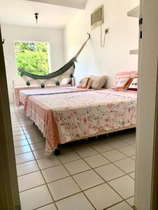 um quarto com uma cama com um baloiço em casa de 4 quartos perto do Forte Orange Itamaracá em Itamaracá