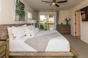 a bedroom with a large white bed with a ceiling fan at Hilton Pool Pass Included - Stylish Central Villa Mins to Beach Pool & Spa in Waikoloa