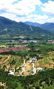 an aerial view of a town with a river and mountains at Happy Valley Eco Farm in Kerling