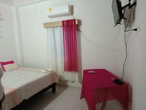 een kamer met een bed, een tafel en een tv bij Hotel Veraneras in Santa Veronica