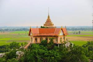 a building on top of a hill with a tower at PEE HOMESTAY LOPBURI in Ban Tha Krayang