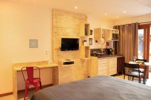 a bedroom with a bed and a desk with a television at Opera Itacaré in Itacaré
