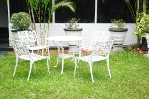 a white table and chairs in the grass at Levi's Tourist – Anuradhapura in Anuradhapura
