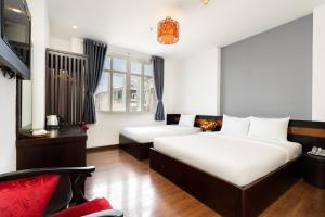 Habitación de hotel con 2 camas y sofá en A&A Toronto Hotel, en Ho Chi Minh