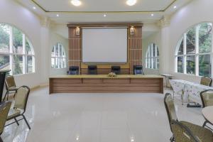 a large meeting room with a blank screen in the middle at RedDoorz Syariah @ Klojen Malang in Malang