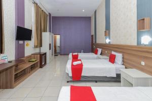 a hotel room with two beds and a flat screen tv at RedDoorz Syariah @ Klojen Malang in Malang