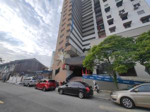 a street with cars parked in front of a tall building at CITY HUNTER At Georgetown in George Town