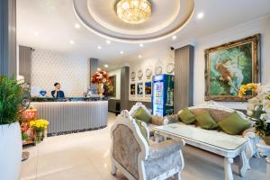 a salon with a couch and chairs in front of a counter at Rosa Hotel & Spa in Ho Chi Minh City