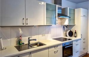 uma cozinha com armários brancos e um lavatório em Gorgeous Apartment In Lichtenfels Ot Kloster With Wifi 