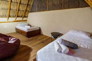 a bedroom with two beds and a table and a tableasteryasteryasteryasteryastery at Casa Mambo Salinas in Santa Veronica