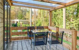 a patio with a table and chairs on a wooden deck at Awesome Home In Well With Kitchen in Well