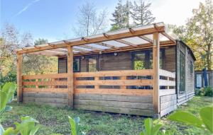 a wooden cabin with a wooden fence in the grass at Awesome Home In Well With Kitchen in Well
