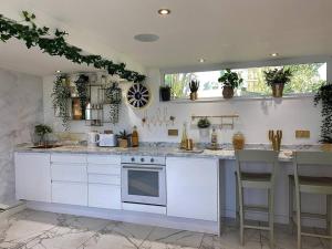 a kitchen with white counters and a stove top oven at Beautiful Boutique With own Hot Tub & Pet Friendly in Stokeinteignhead