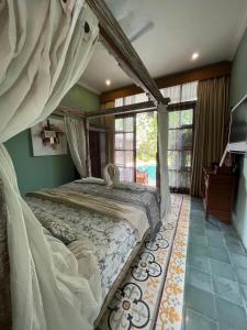 ein Schlafzimmer mit einem Himmelbett in einem Zimmer in der Unterkunft Villa Gekyu in Jimbaran