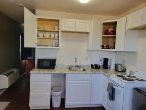 a kitchen with white cabinets and a sink and a stove at 084A Cozy Retreat with Kitchen nr South Rim Sleeps 4 in Valle