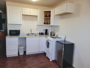 a kitchen with white cabinets and a white stove top oven at 084A Cozy Retreat with Kitchen nr South Rim Sleeps 4 in Valle