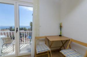 a room with a table and chairs and a balcony at Apartments and rooms Mini - parking in Bol