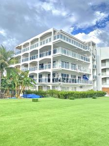 a large white building with a lawn in front of it at Caribbean Oasis on Sunset Beach in Maho Reef