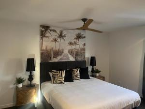 um quarto com uma cama grande e uma ventoinha de tecto em Plantation Hotel Coffs Harbour em Coffs Harbour