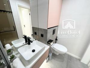 bagno con lavandino bianco e servizi igienici di LUX на берегу Иртыша a Pavlodar