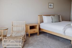 una camera con letto, sedia e tavolo di Haven on James a Bicheno