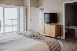 um quarto com uma cama, uma televisão e uma casa de banho em Haven on James em Bicheno