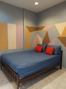 Un dormitorio con una cama con una pared colorida. en BEN HOUSE, en Ban Na Song