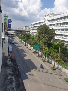 una calle vacía frente a un gran edificio en BEN HOUSE, en Ban Na Song