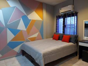 Un dormitorio con una cama con una pared colorida. en BEN HOUSE, en Ban Na Song 14 fotos más